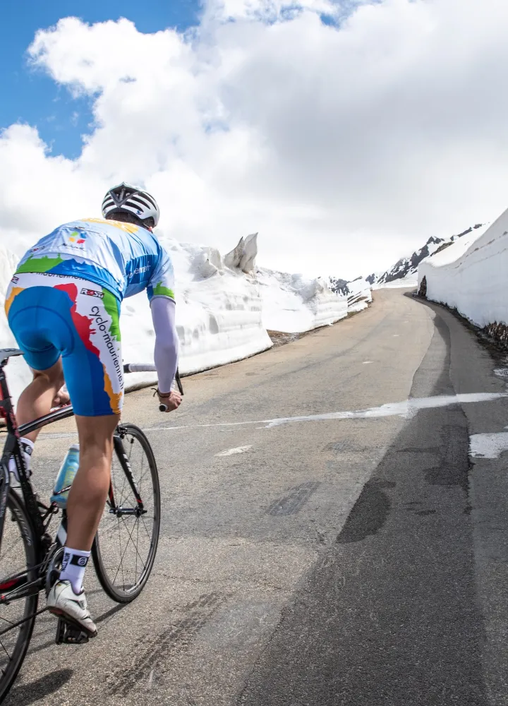 Fietser in de sneeuw op de Route des Grandes Alpes