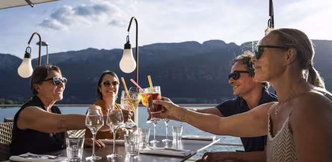 amis à l'apéritif sous parasol vue sur le lac d'annecy