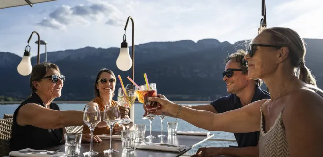 amis à l'apéritif sous parasol vue sur le lac d'annecy